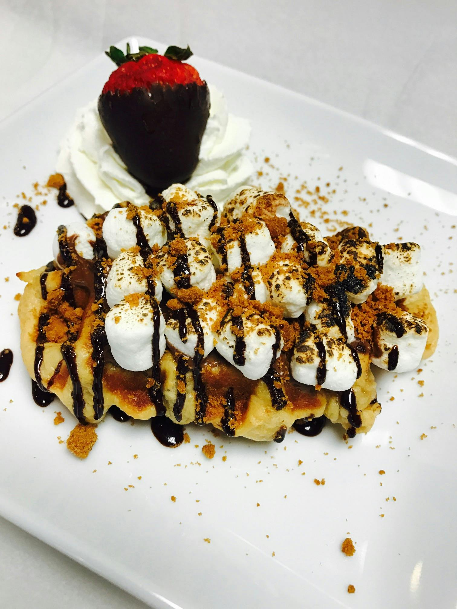 a piece of cake covered in chocolate sitting on top of a white plate