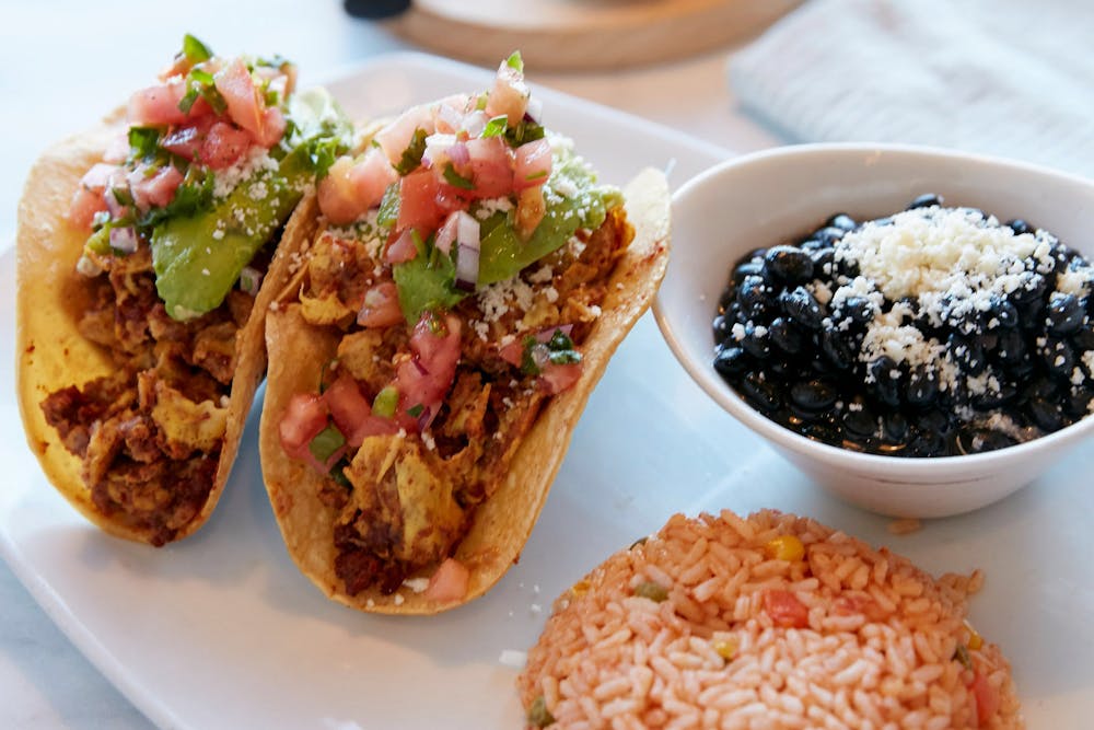 South of the border title. photo of two tacos, black beans and spanish rice