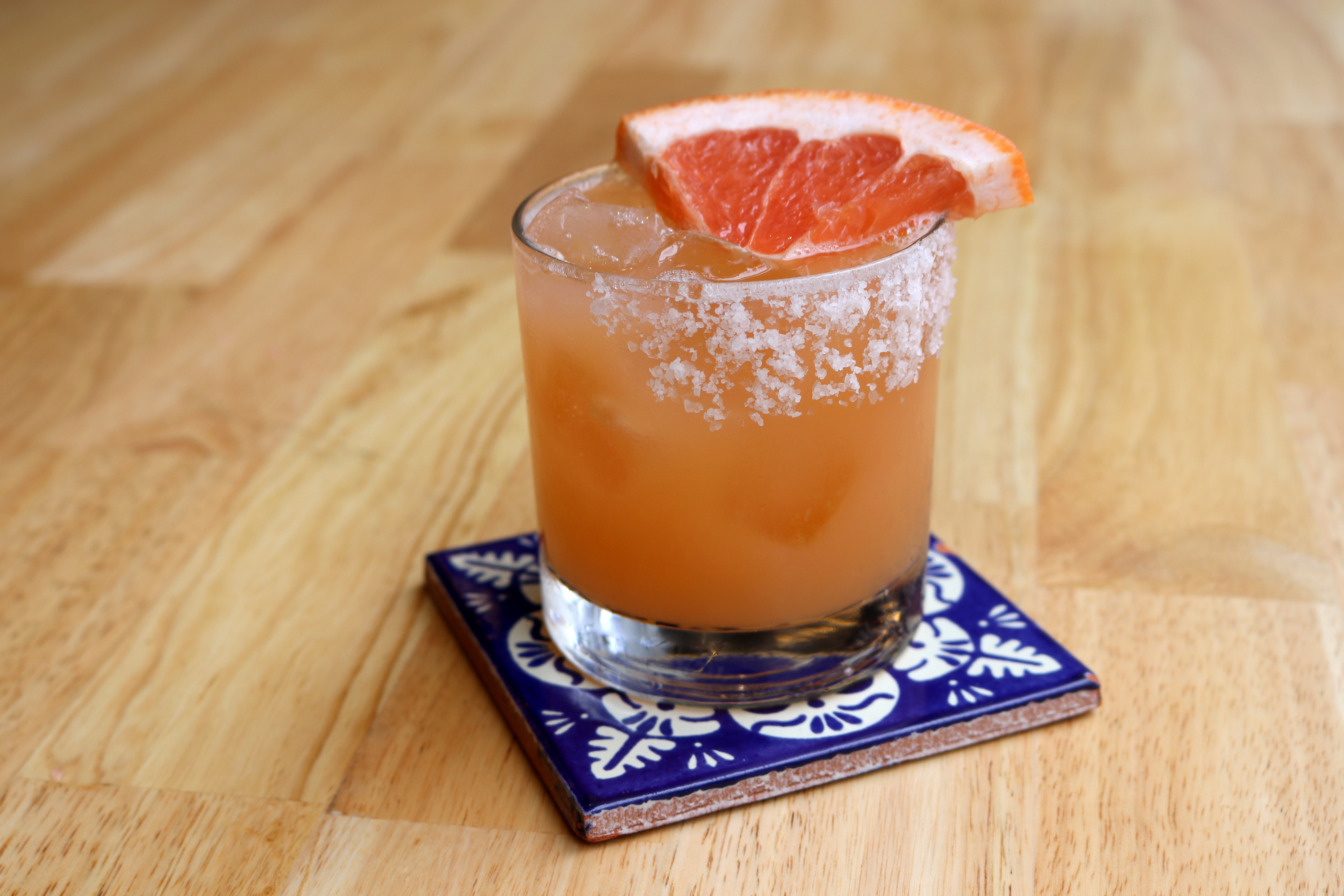 a glass with a drink and a slice of orange on top