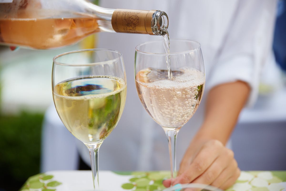 a person sitting at a table with wine glasses
