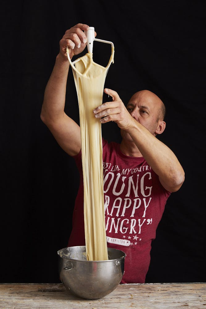 a person stretching dough