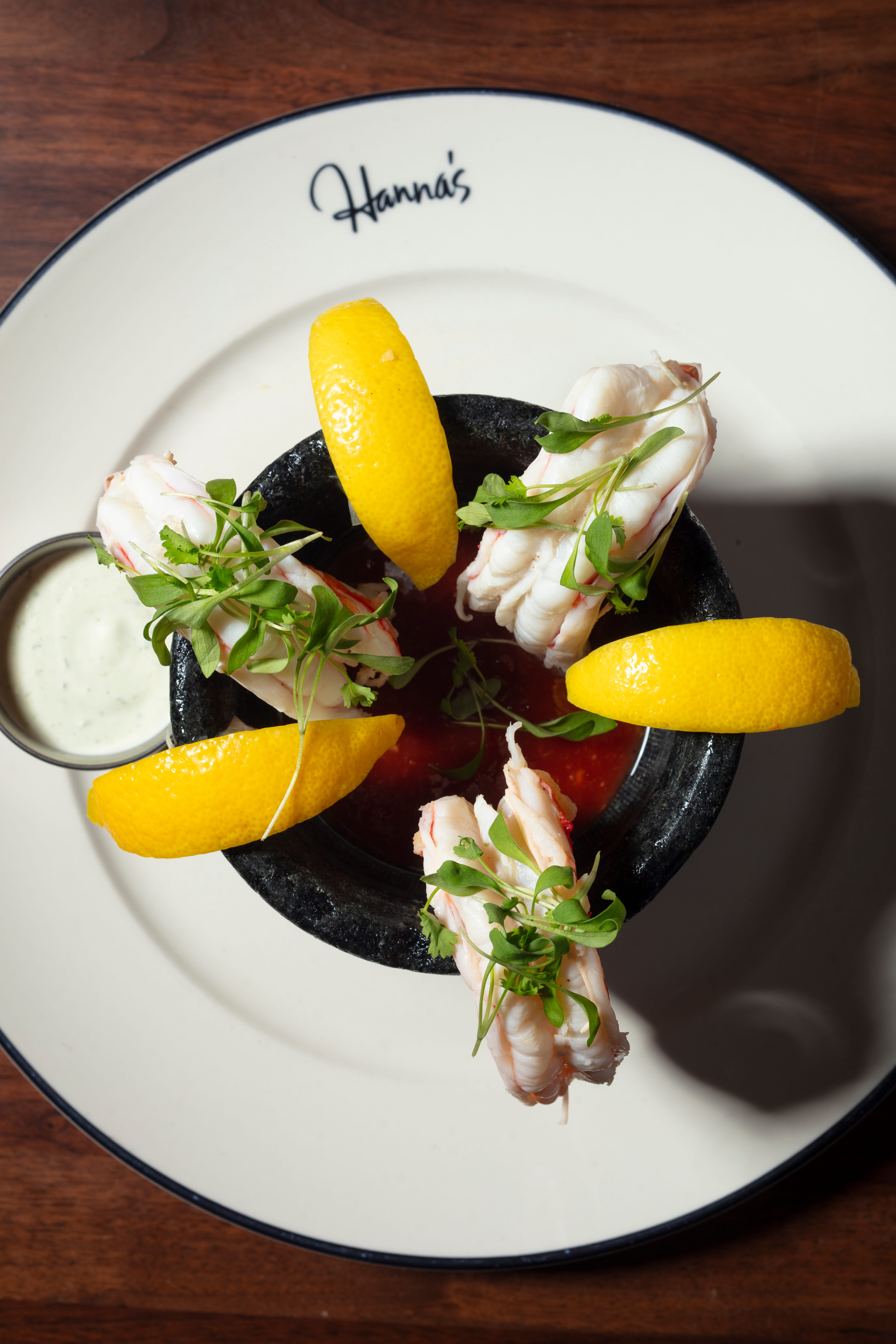a plate of food with lemons and sauce