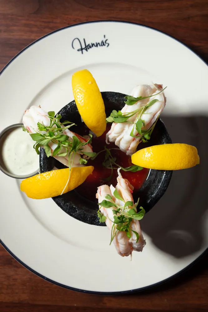 a plate of food with lemons and sauce