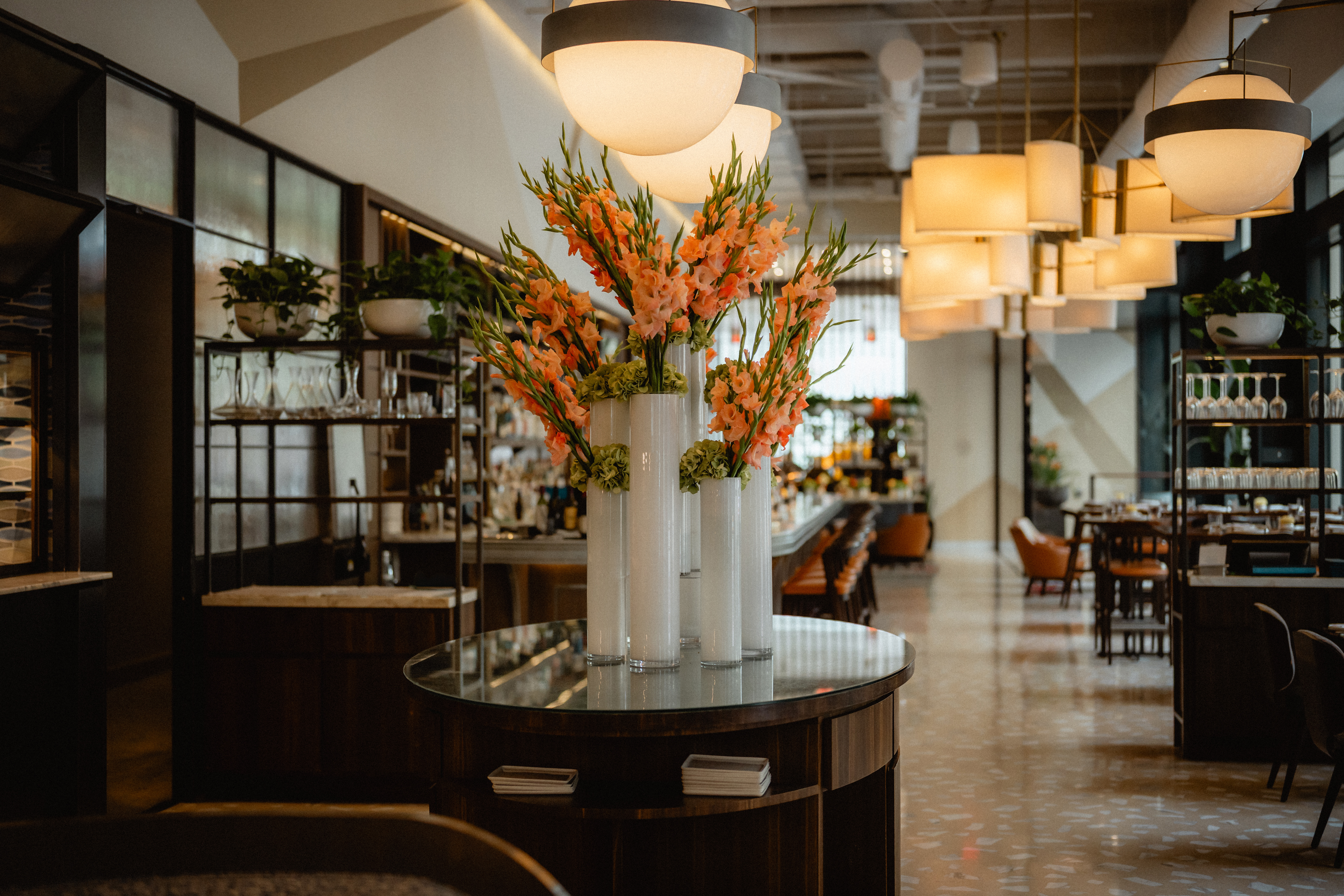 a group of flowers in vases on a table in a restaurant