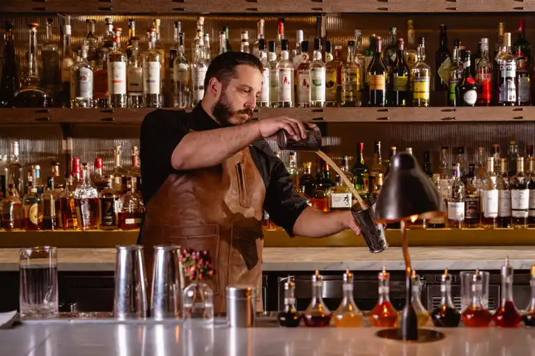 a man sitting at a table with wine glasses