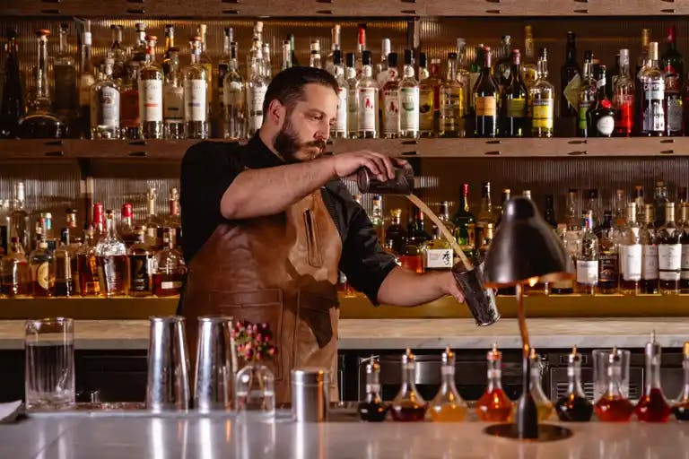 a man sitting at a table with wine glasses