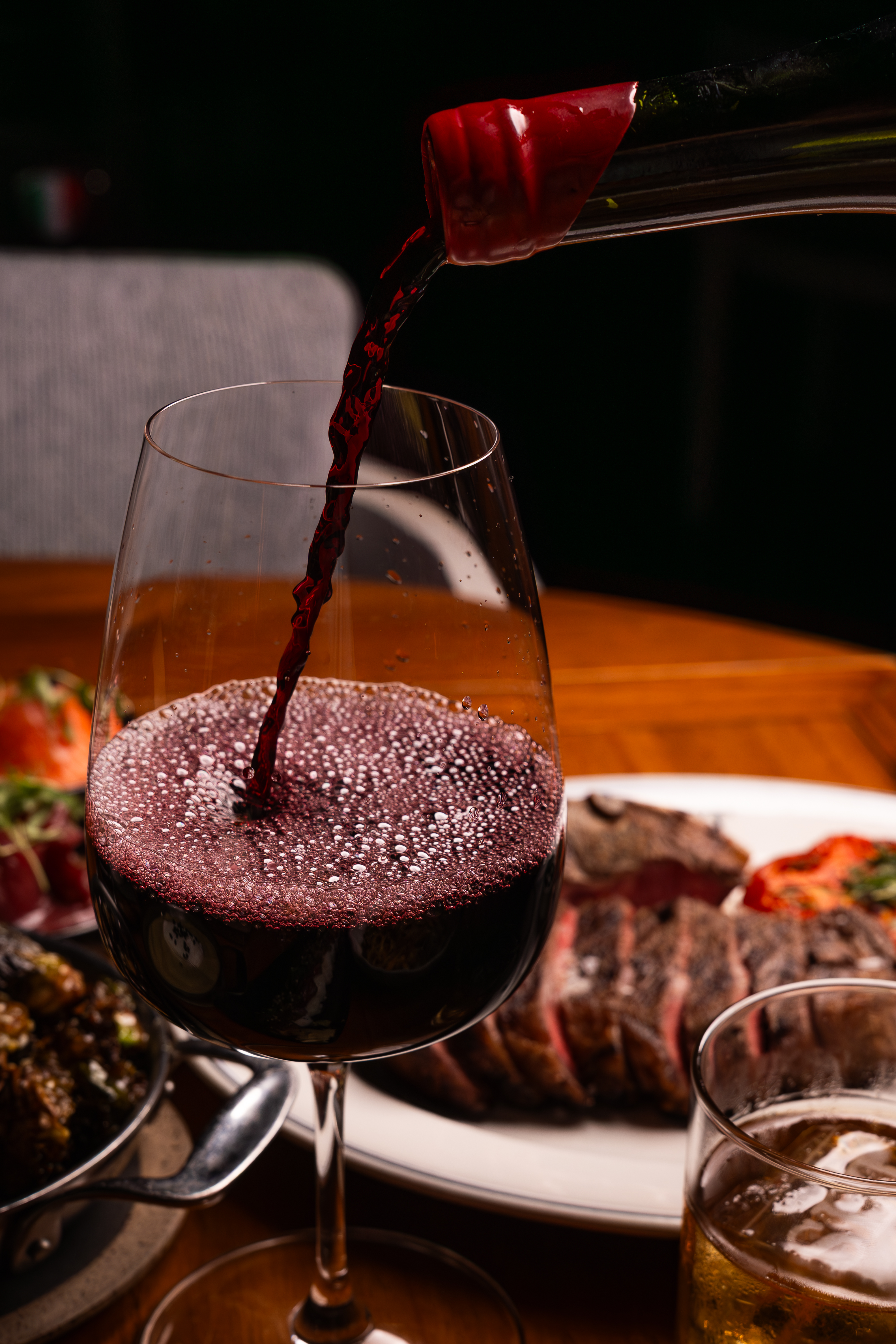 a glass of wine sitting on top of a wooden table