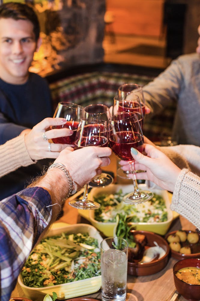 a person sitting at a table drinking wine