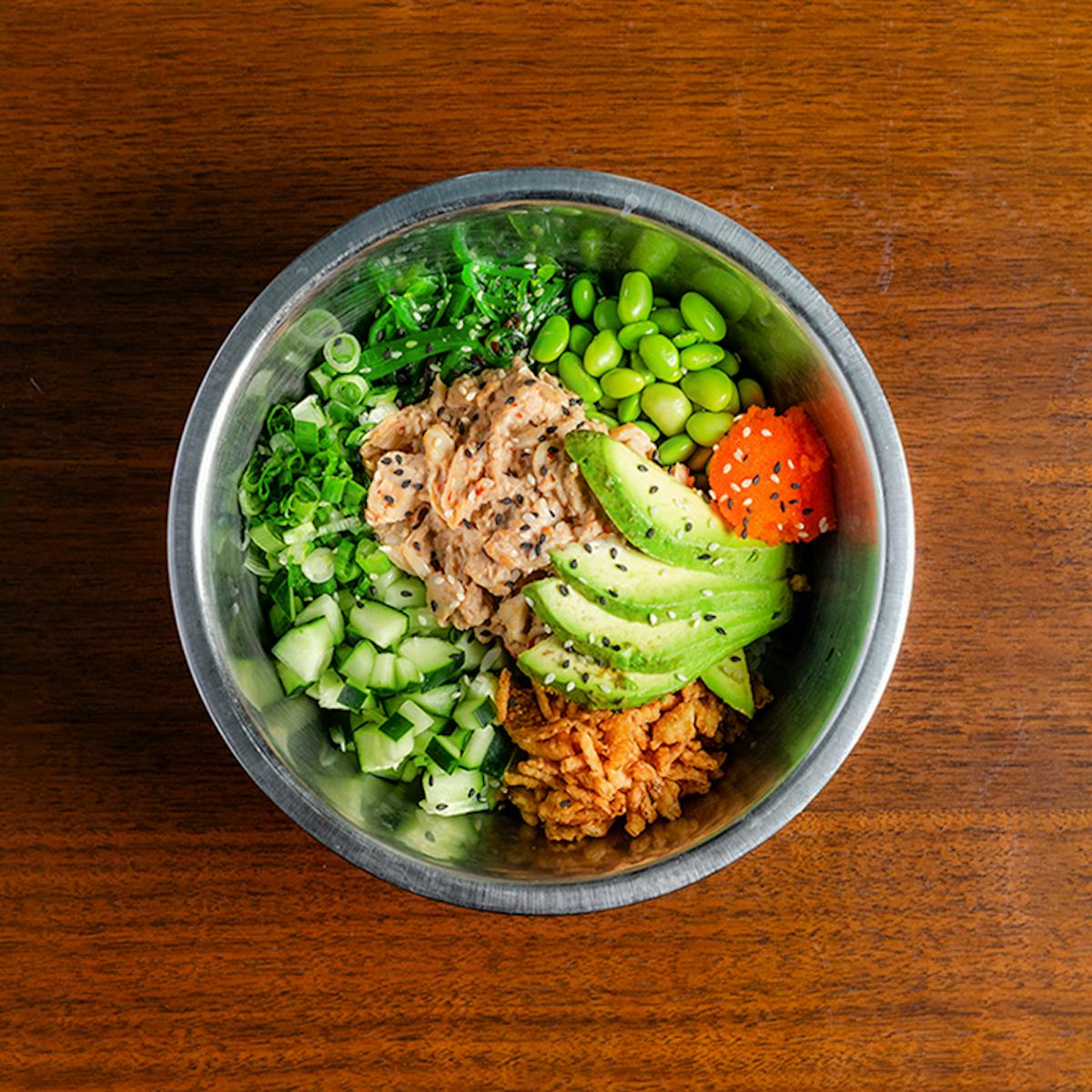 a bowl of broccoli sitting on top of a wooden table