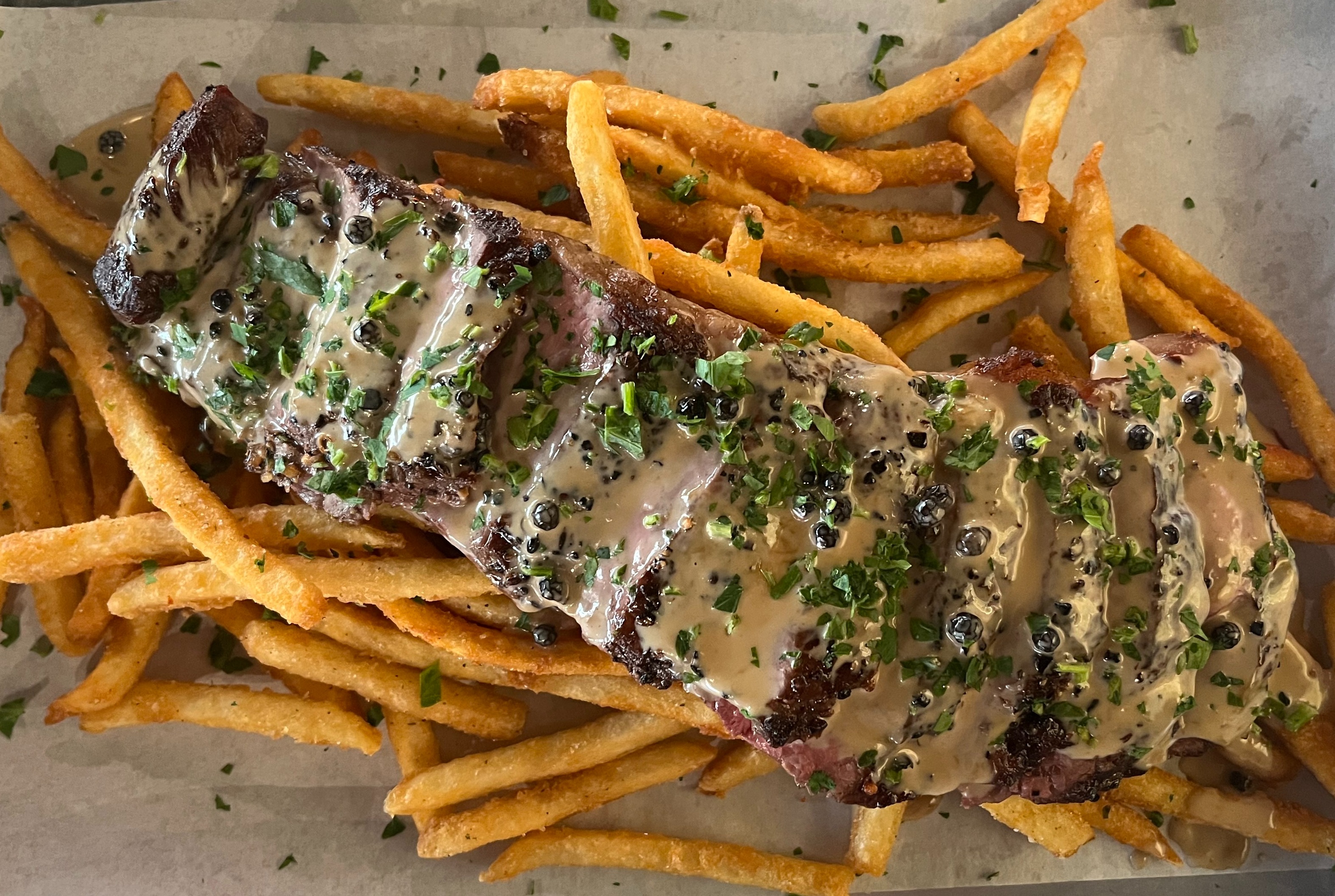 a hot dog sitting on the side of fries