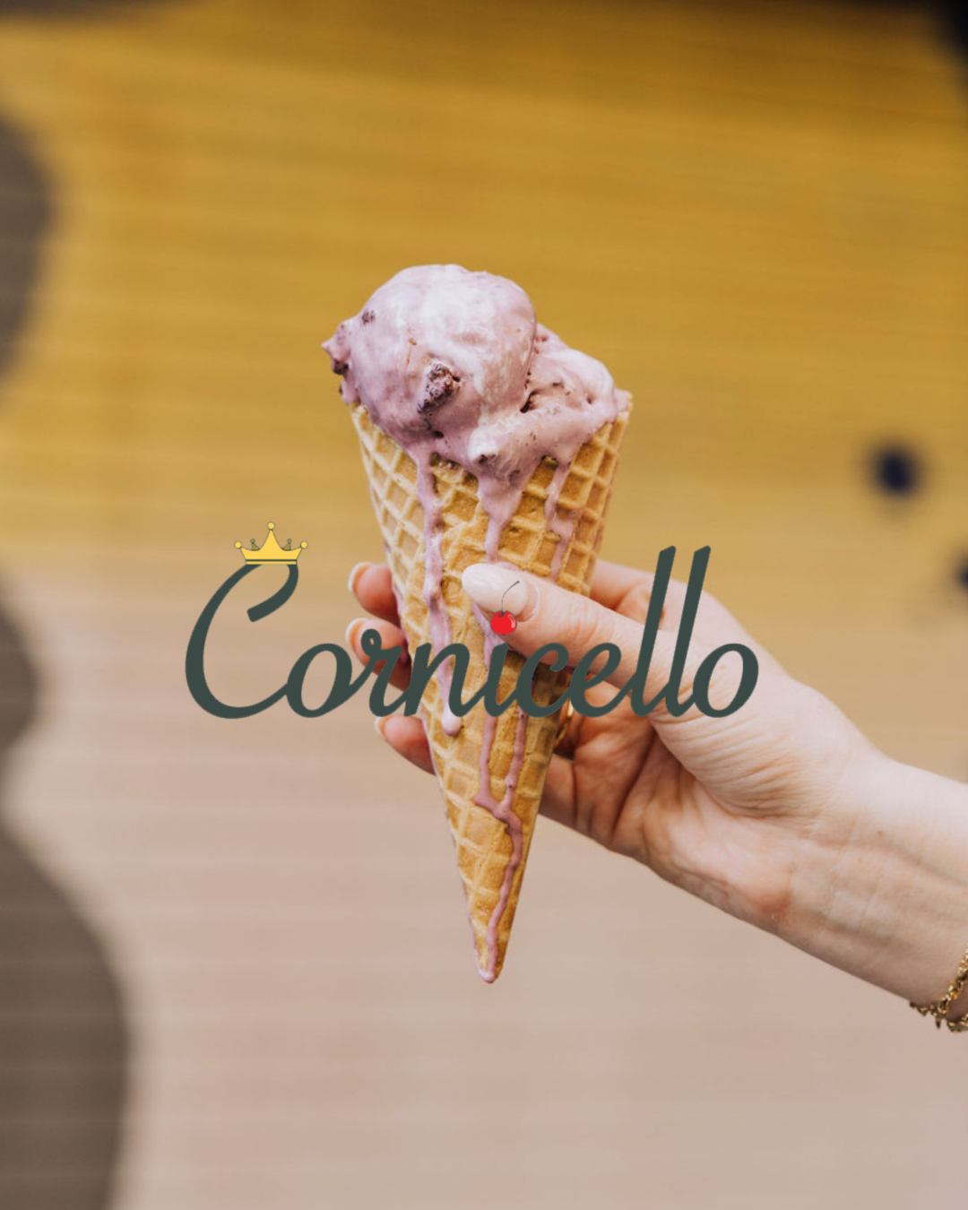 a hand holding a cone with ice cream