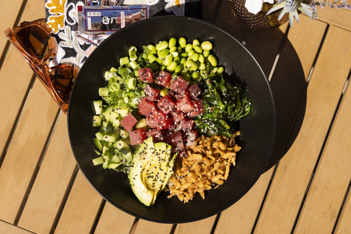 a bowl of food sitting on top of a wooden table