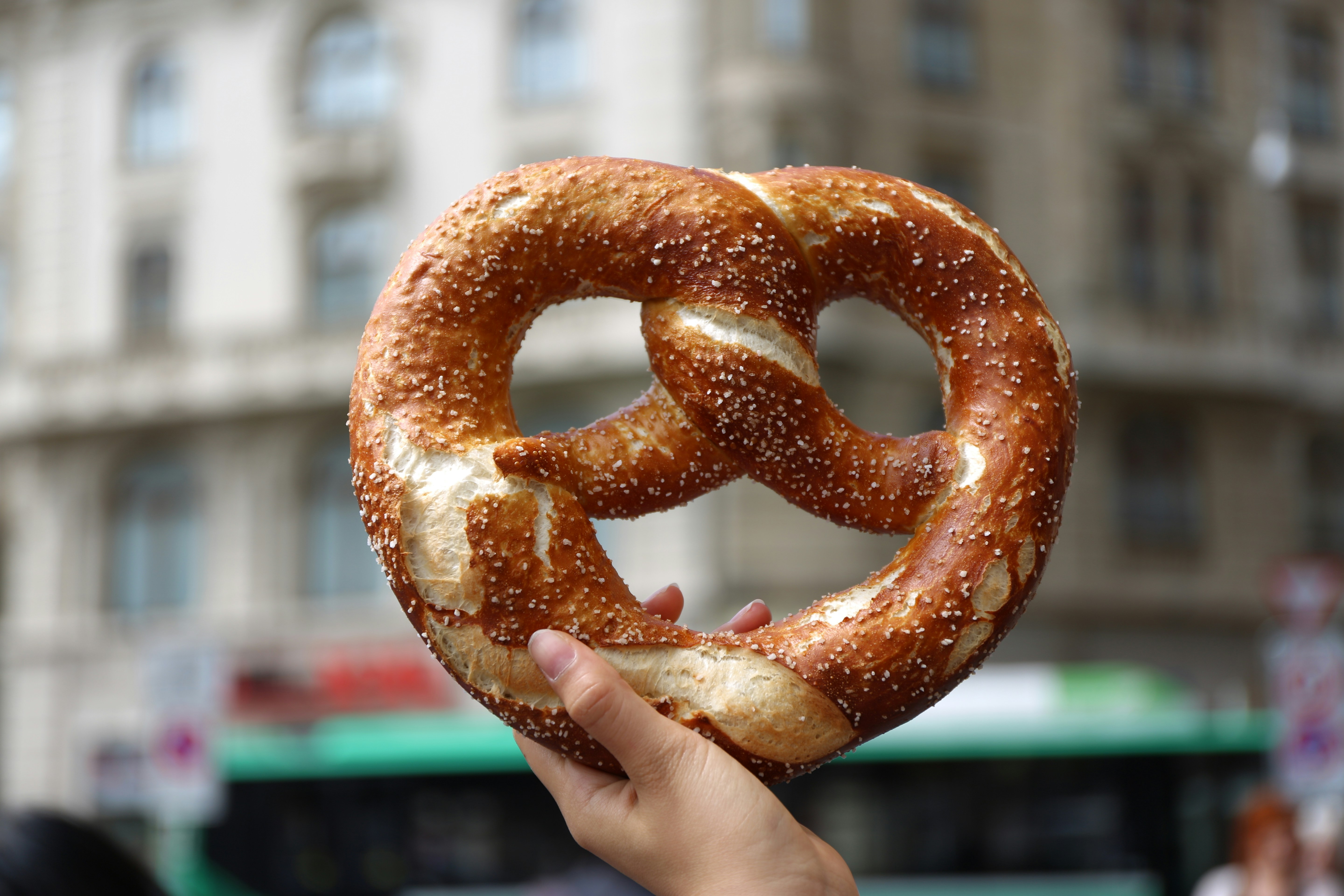 a hand holding a large pretzel
