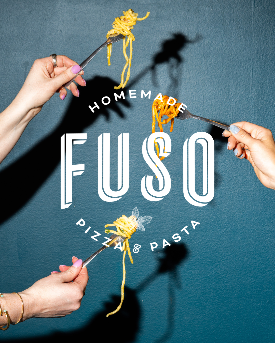 a group of hands holding forks with pasta