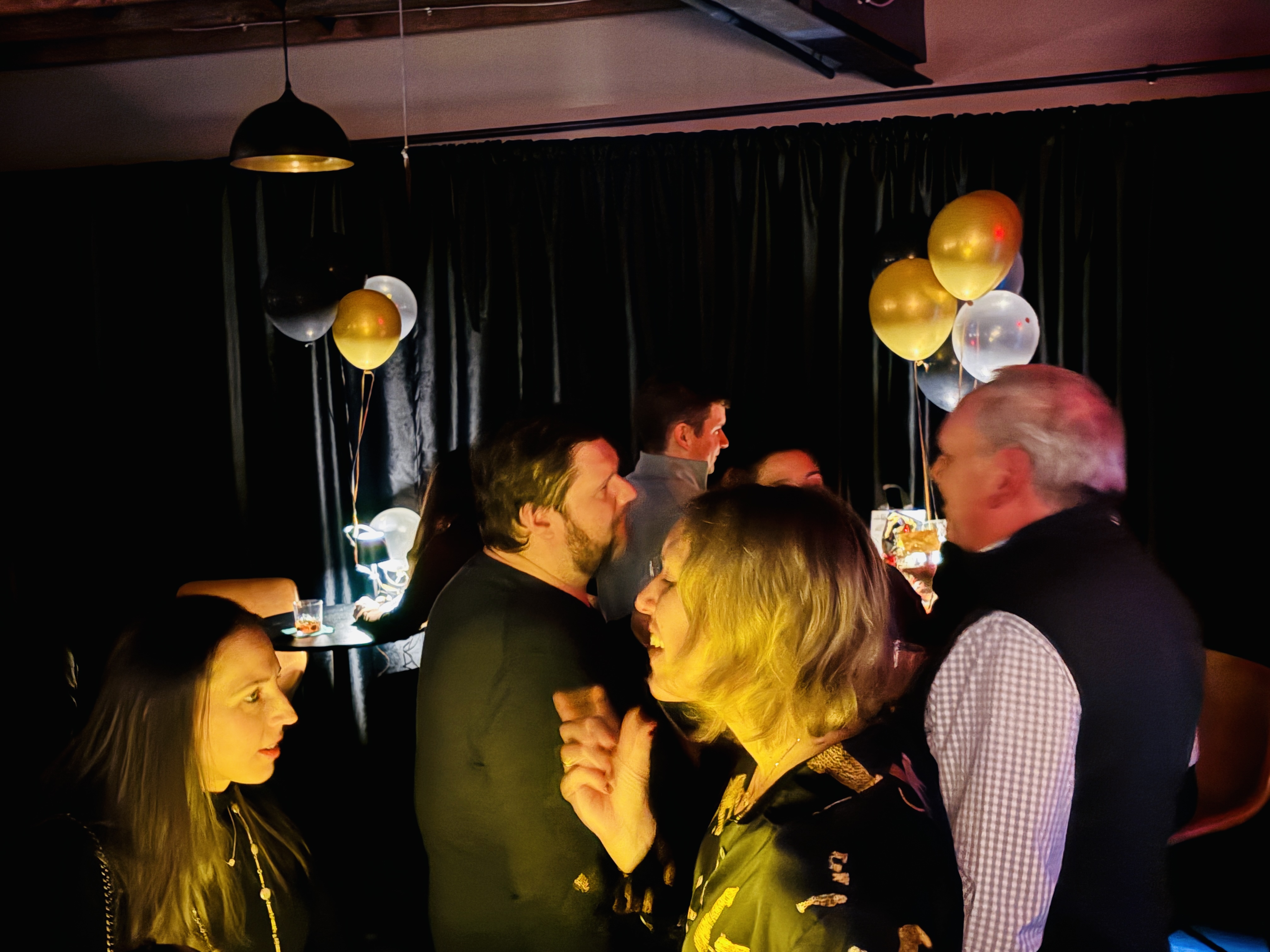 a group of people in a room with balloons