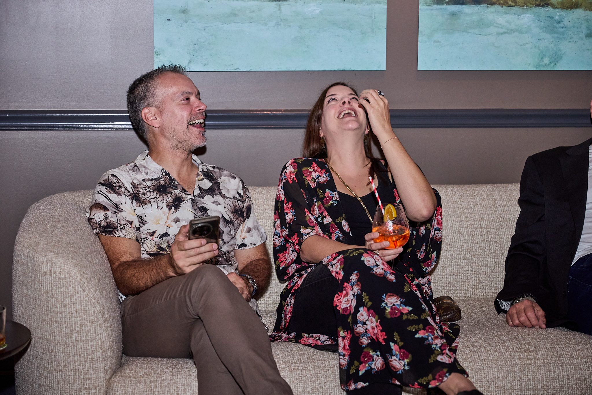 a man and woman sitting on a couch laughing