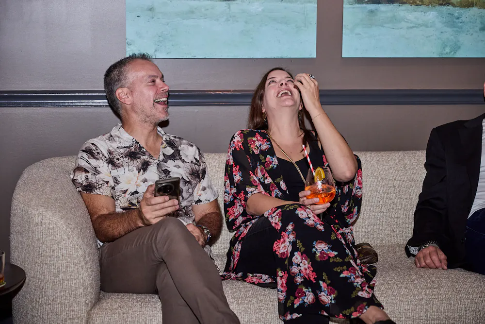 a man and woman sitting on a couch laughing