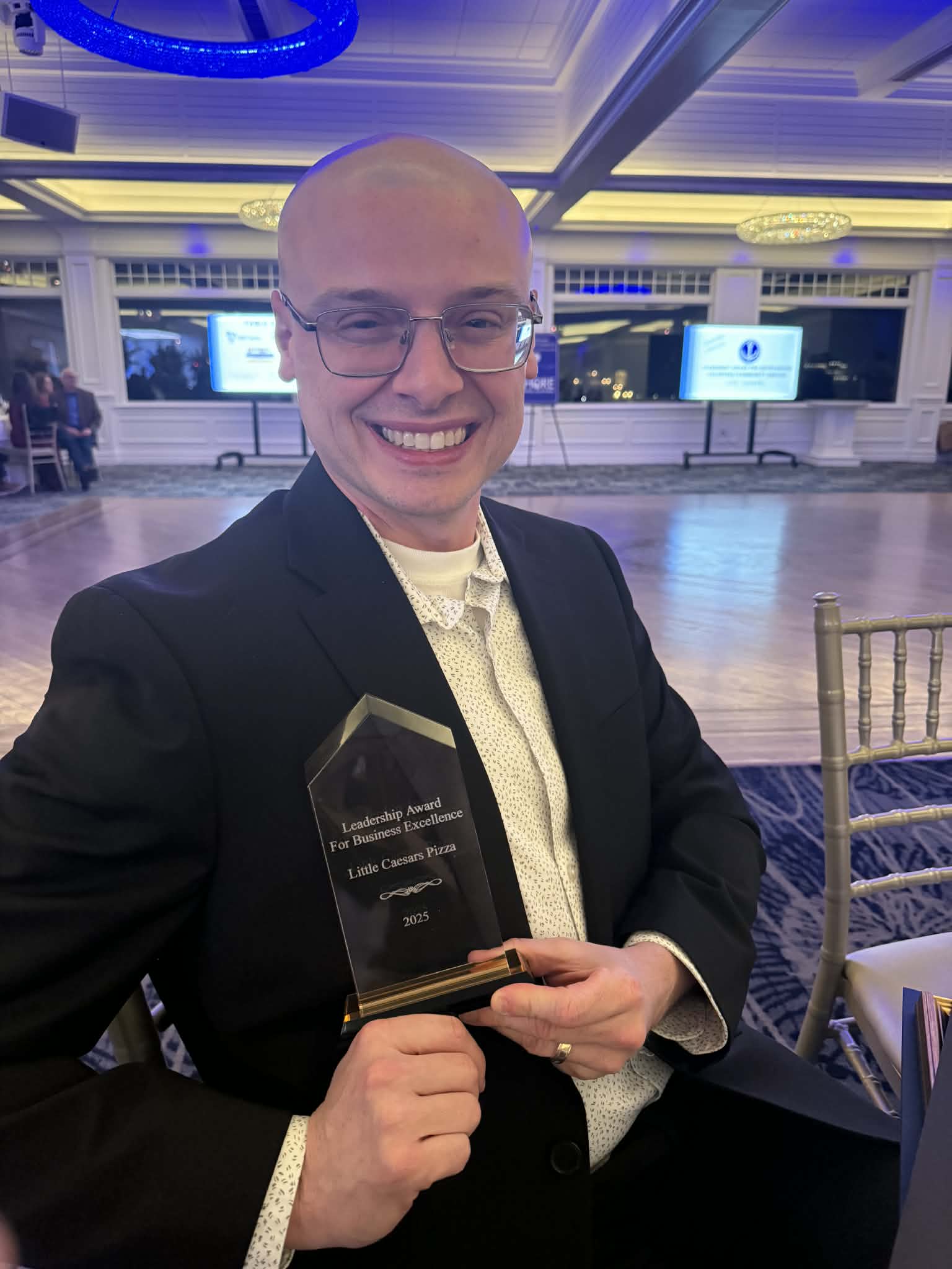 a man in a suit holding a trophy