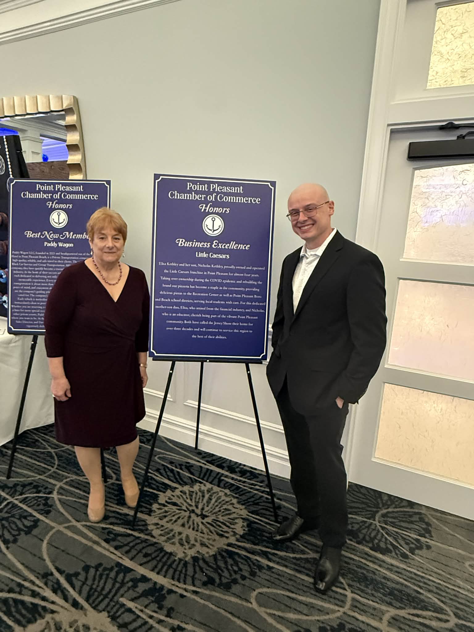 a man and woman standing next to a sign