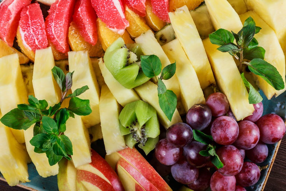 a plate is filled with fresh fruit and vegetables