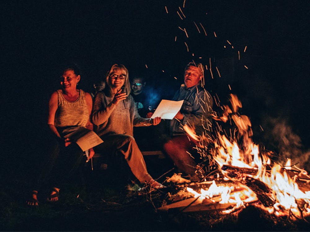 a group of people standing around a fire