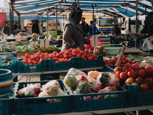 a group of people in a store filled with lots of fresh produce