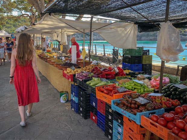 a woman standing in front of a fruit stand