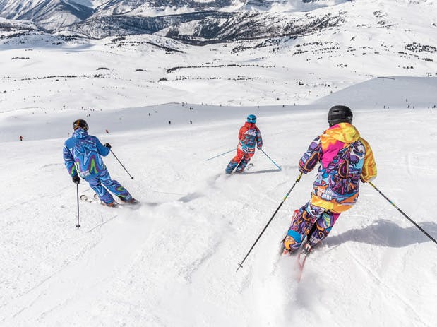 a group of people skiing down a snow covered slope