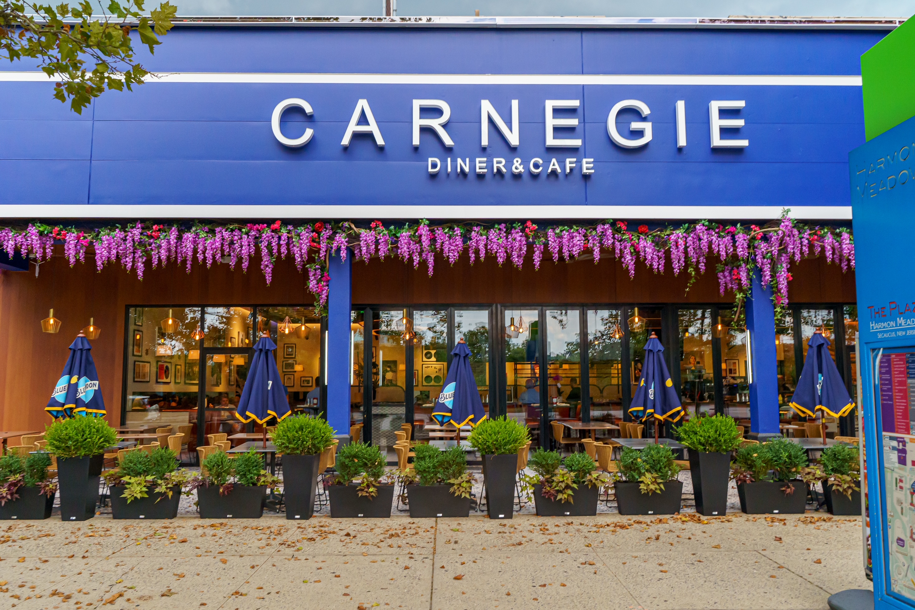 a restaurant with a sign and flowers