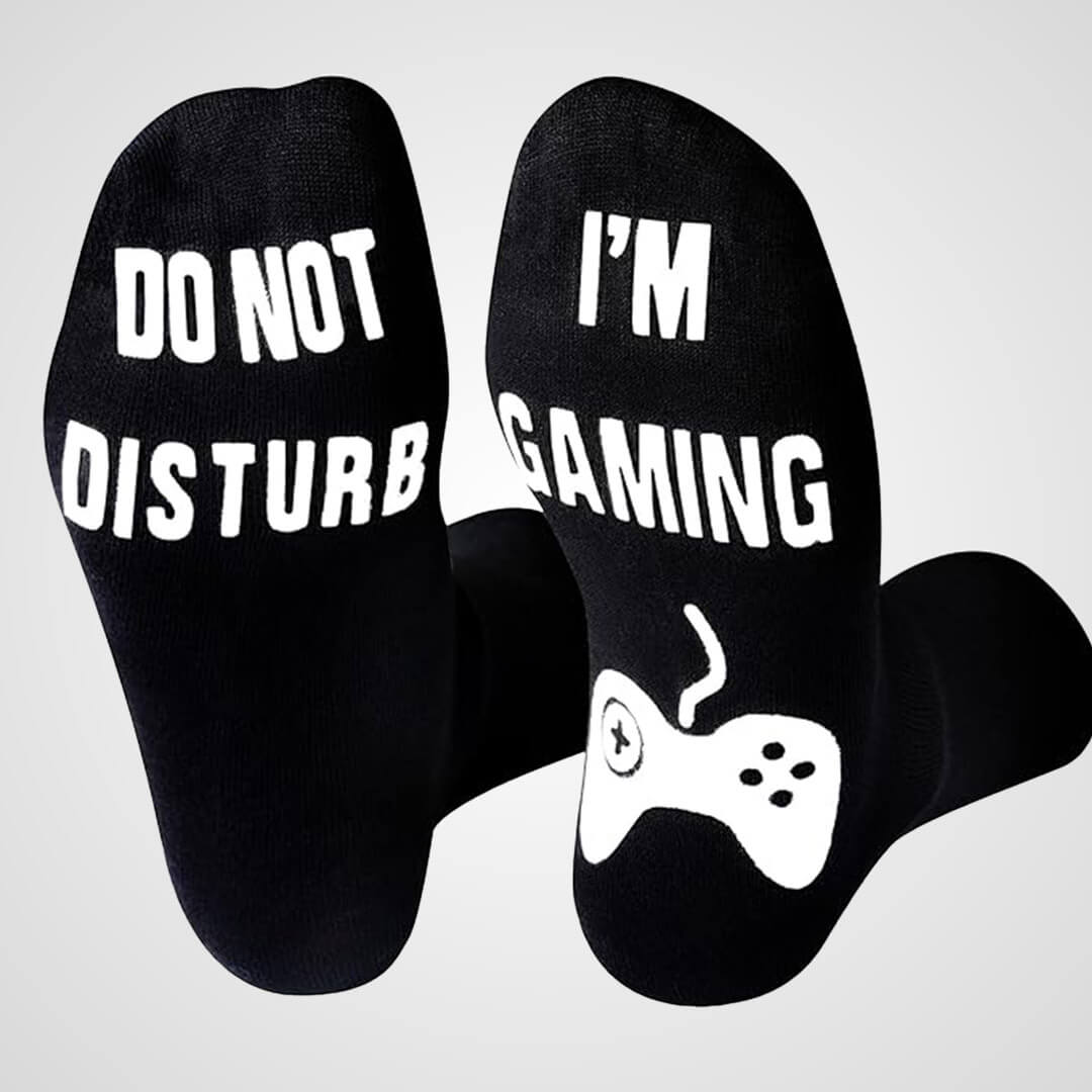 A pair of black novelty crew socks featuring white text on the soles that reads 