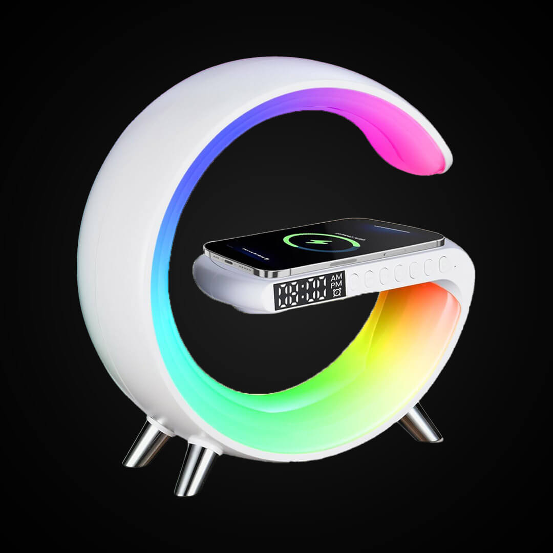 A modern white G-shaped smart desktop lamp glowing with a rainbow LED gradient while wirelessly charging a smartphone.