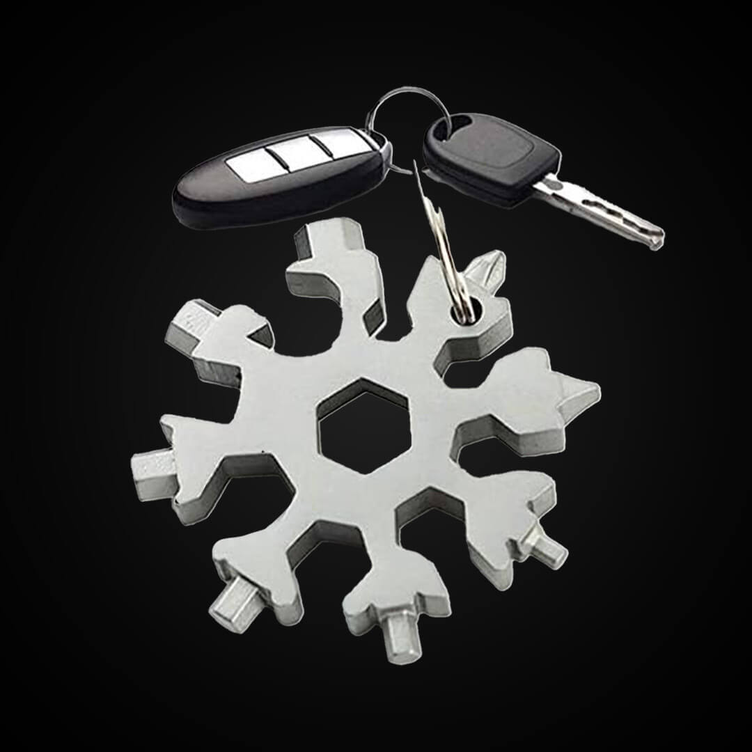 A silver stainless steel snowflake shaped multi-tool keychain shown attached to a car key ring.