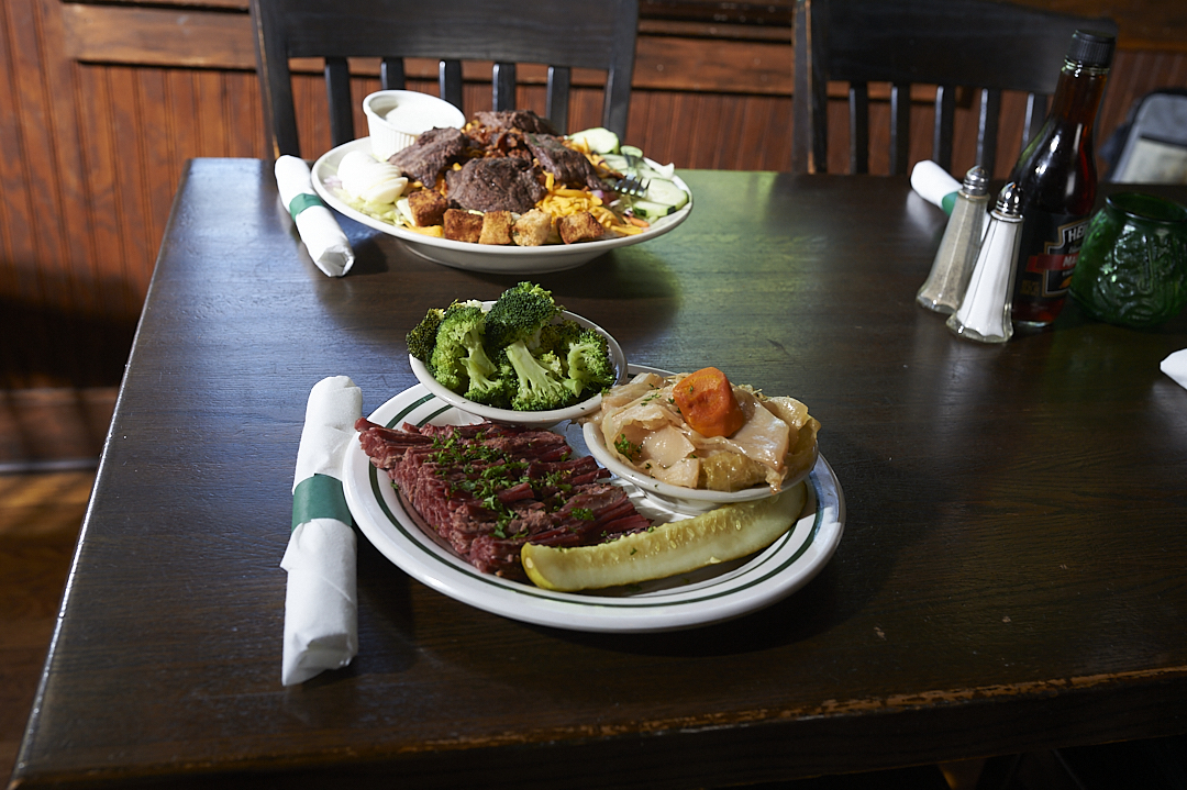 a wooden table topped with plates of food on a plate