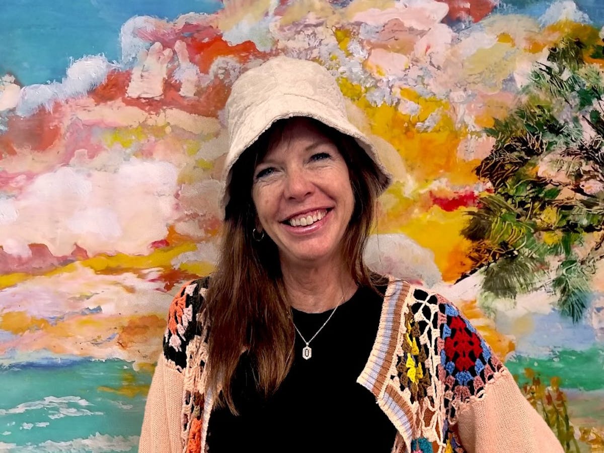 a woman wearing a hat and smiling at the camera