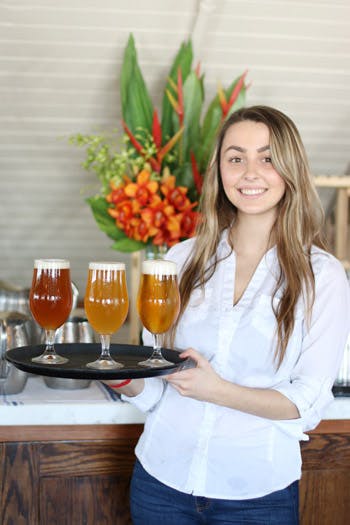 a woman sitting at a table with wine glasses