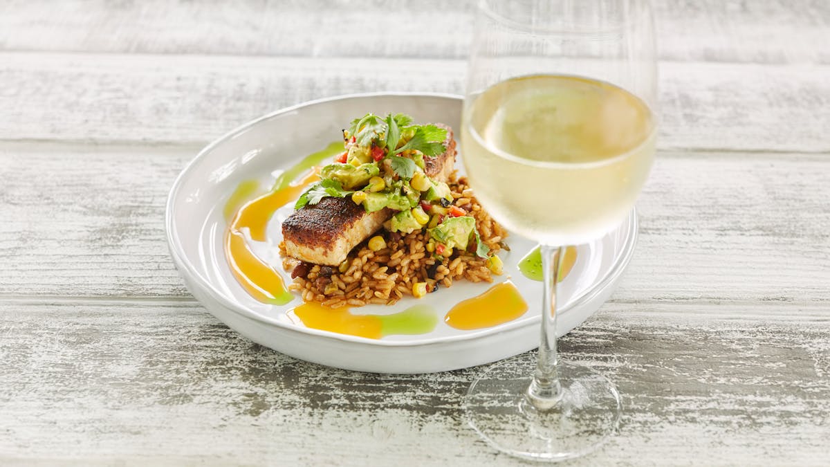 Blackened swordfish on rice with glass of wine