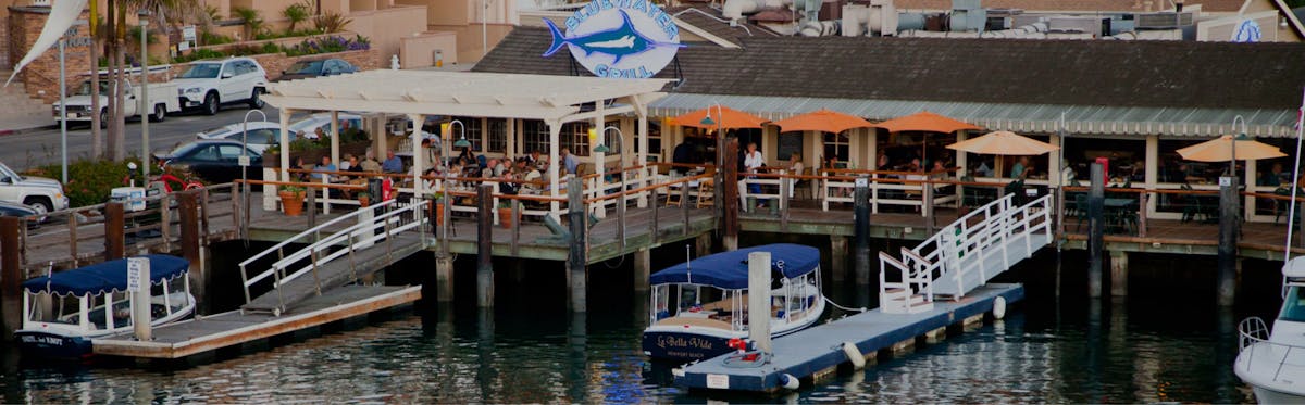 Bluewater Newport exterior view of restaurant on the water with boat docked