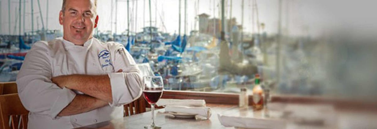 a man sitting at a table with wine glasses