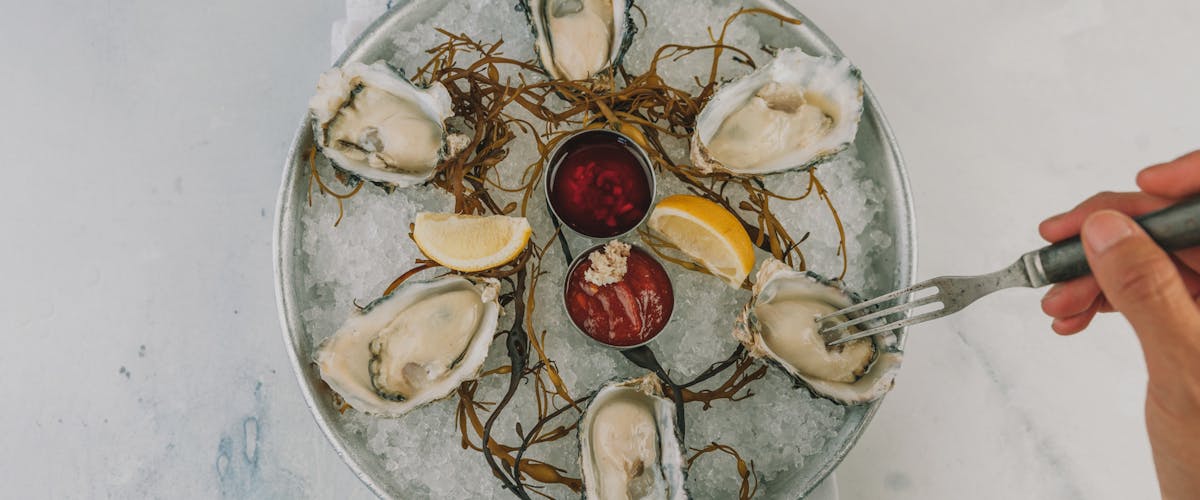 oysters on ice with lemon and dipping sauces