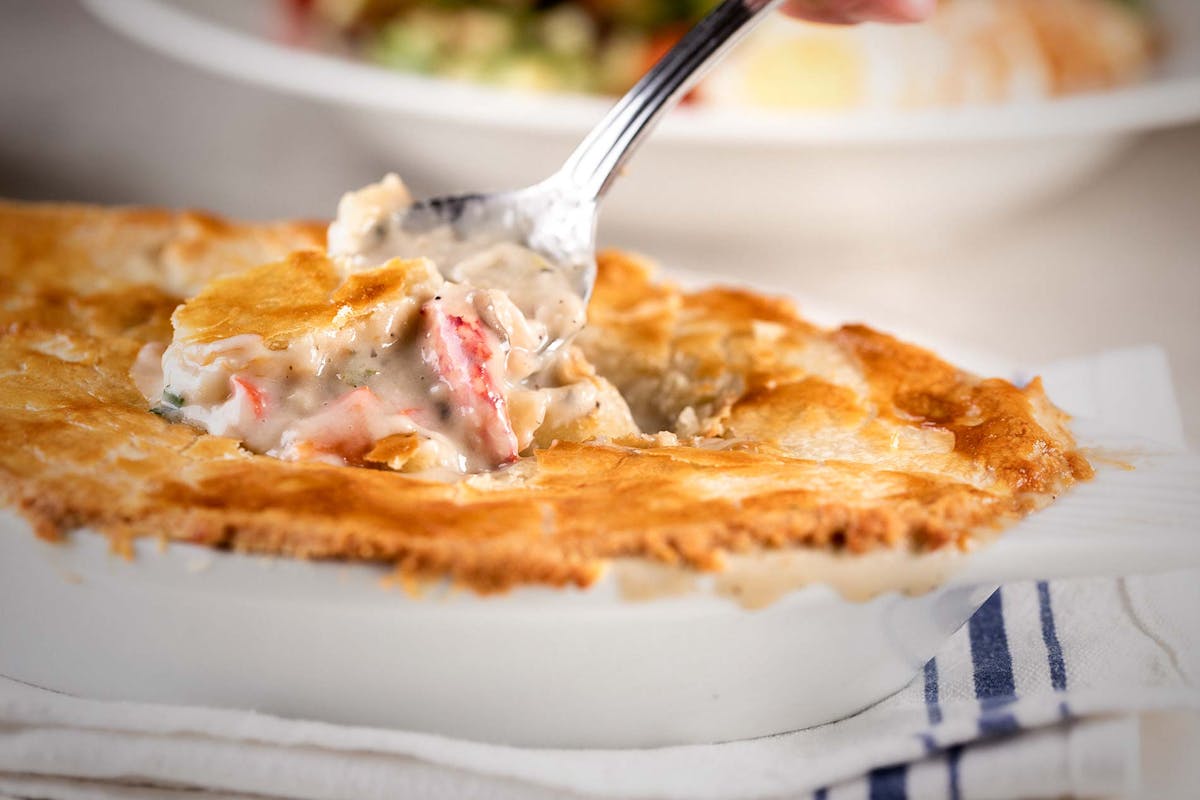 Spoon showing the saucy filling inside the Lobster Pot Pie