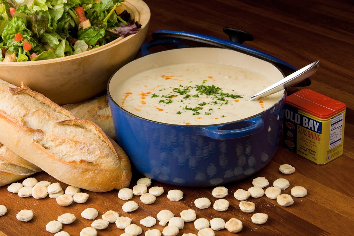 Happy as a Clam! Image of a pot of New England Clam Chowder with salad and bread.