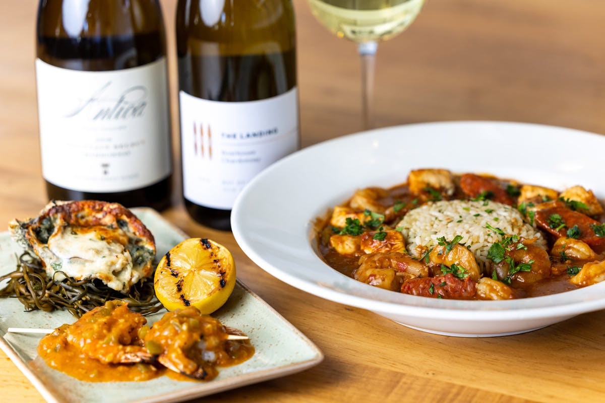 Two bottles of wine, gumbo, Oyster Rockefeller, Shrimp Étouffé