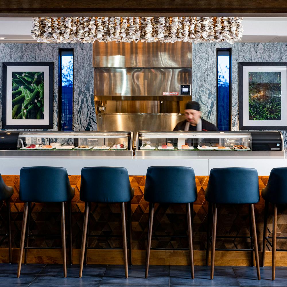 New sushi bar at Bluewater Phoenix. Sushi chef behind open counter with bar and chairs