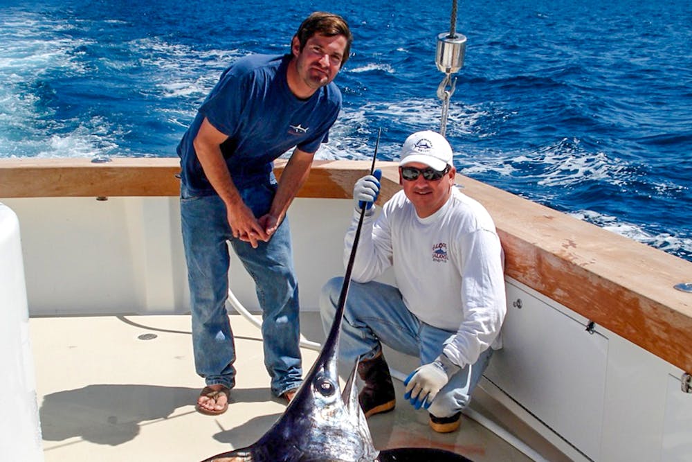 a man cooking hot dogs on a grill