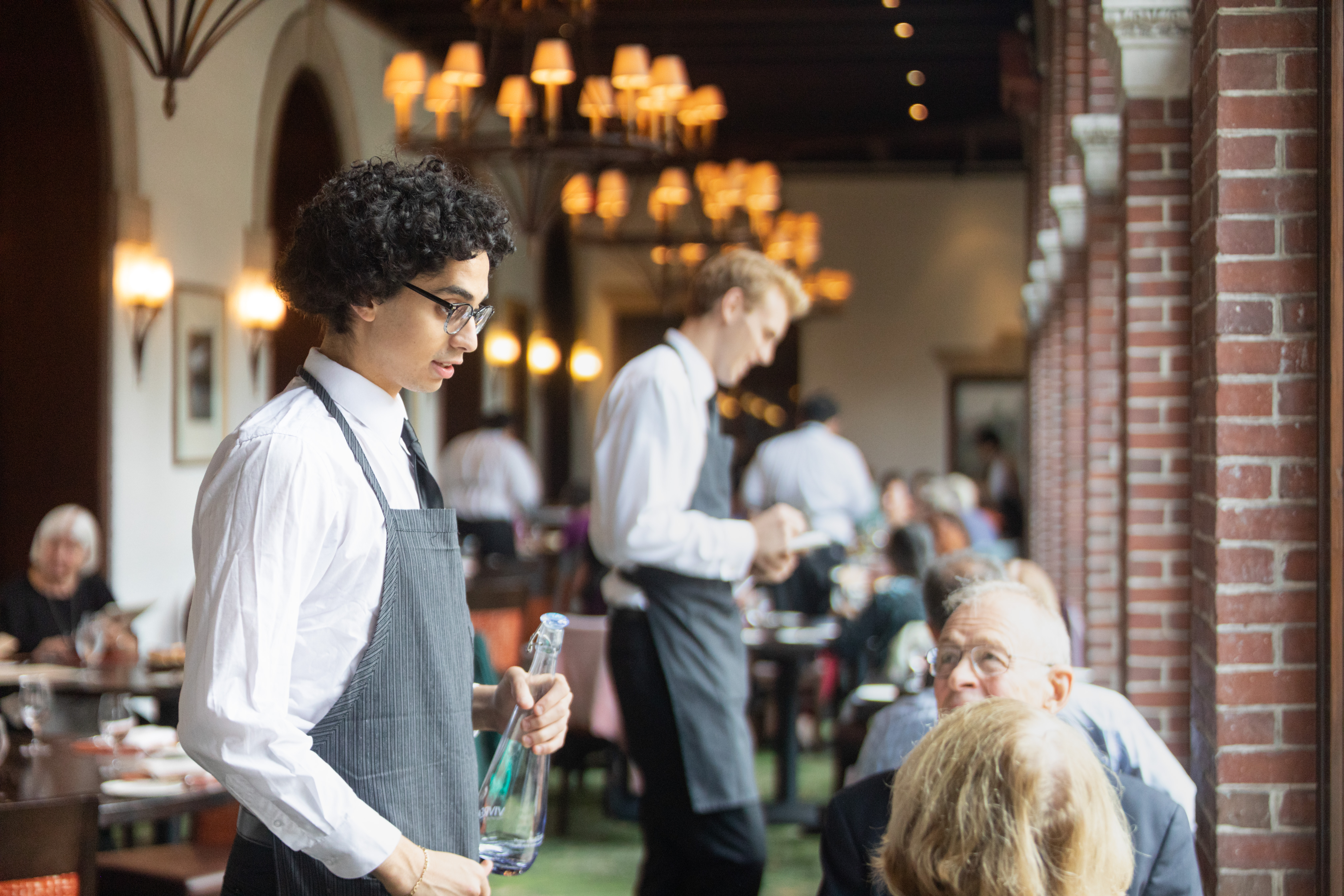 a man holding a bottle of water in a restaurant