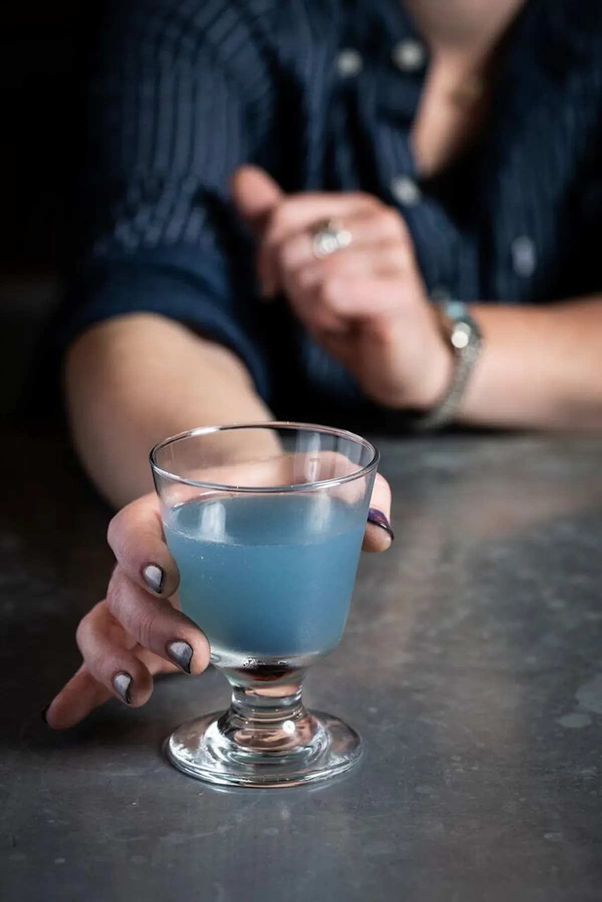 a person holding a glass of beer on a table