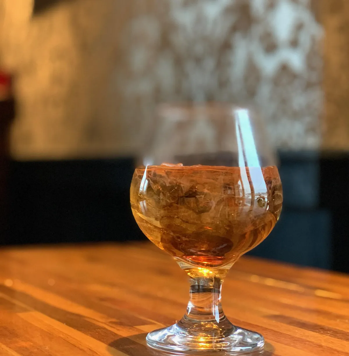 a glass of wine sitting on top of a wooden table