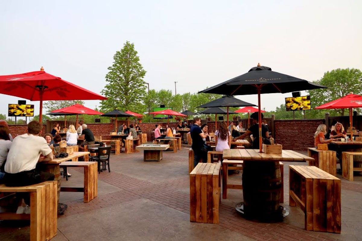 a grEmbrace the Charm of Al Fresco Dining at Brick & Bourbon: Your Ultimate Outdoor Restaurant in St. Cloudoup of people sitting at a picnic table