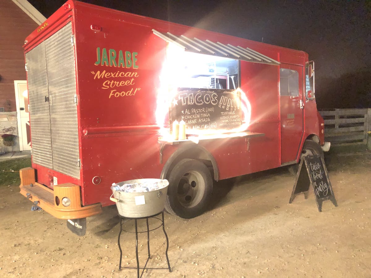 a picture of a red catering truck at night