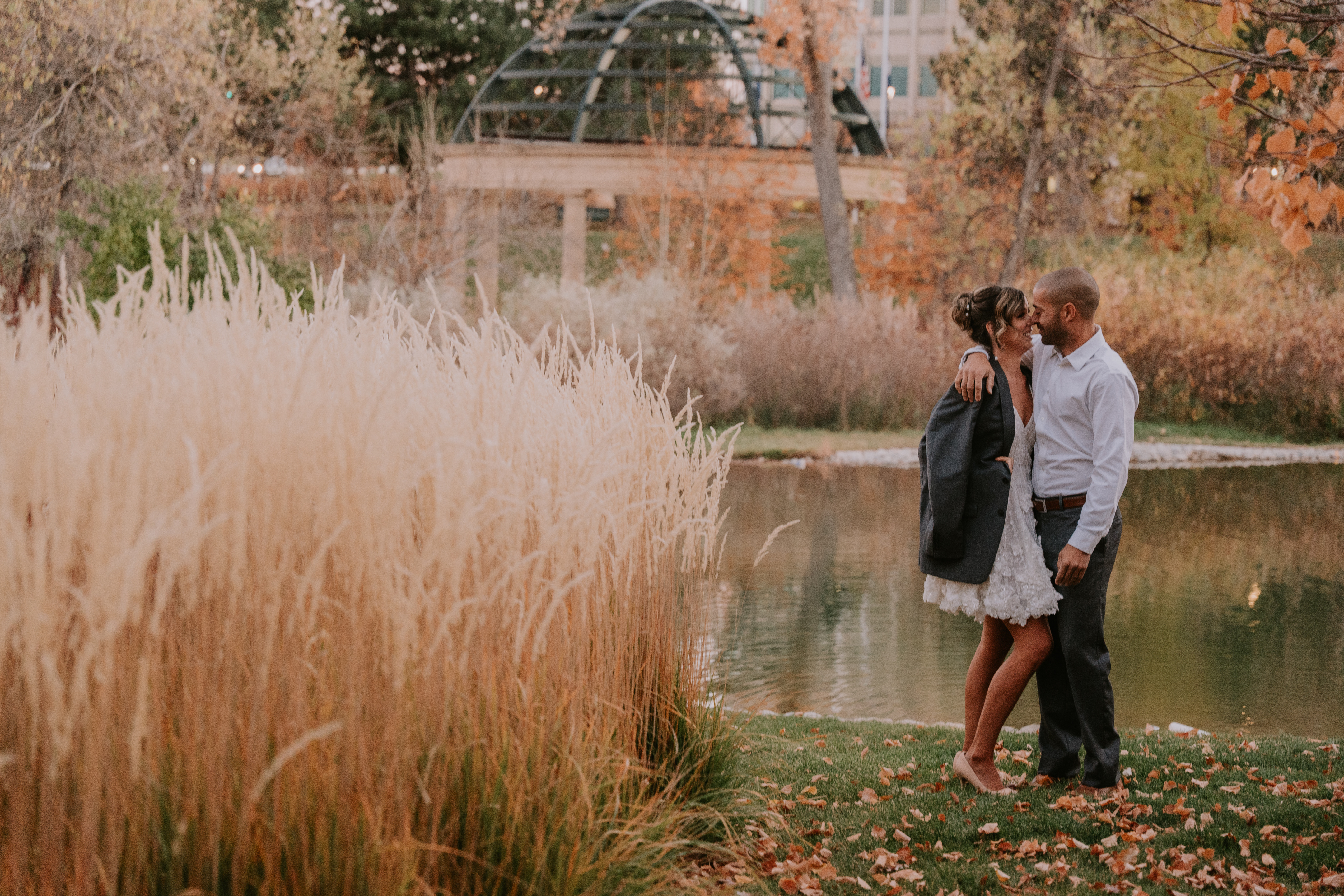 a person that is standing in the grass near water